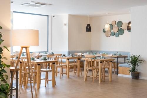 a dining room with wooden tables and chairs at Reserva FLH Hotels Ericeira in Ericeira
