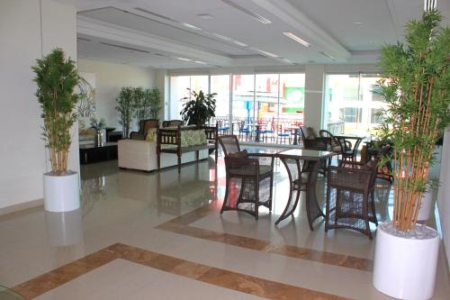 a lobby with a table and chairs and plants at Astur Hotel & Residence in Veracruz