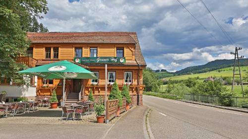 a building with an umbrella and tables and chairs at Grüner Hof in Zell am Harmersbach