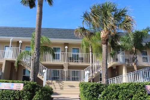 a building with palm trees in front of it at Inn on the Gulf in Hudson