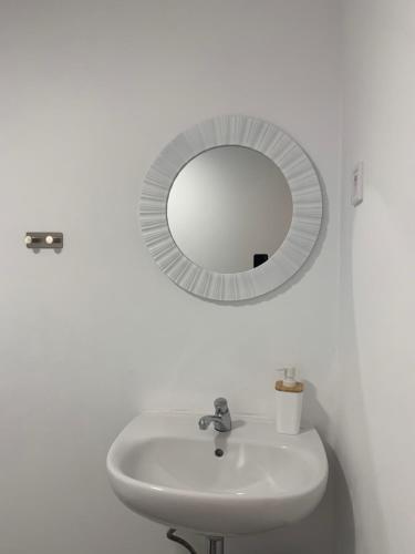 a white bathroom with a sink and a mirror at Santo Amaro Apartment in Lisbon