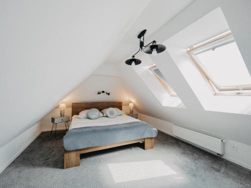 a attic bedroom with a bed and two skylights at Apartament Rynek Pniewy in Pniewy