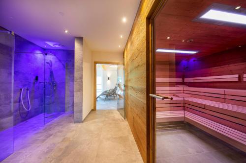 a bathroom with purple walls and a walk in shower at Hotel Post Krimml in Krimml