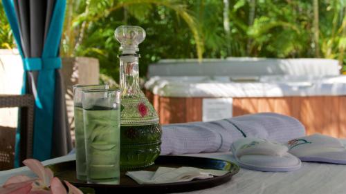 una botella de líquido verde sentada en una mesa con un vaso en Casa Cupula Luxury LGBT Boutique Hotel, en Puerto Vallarta