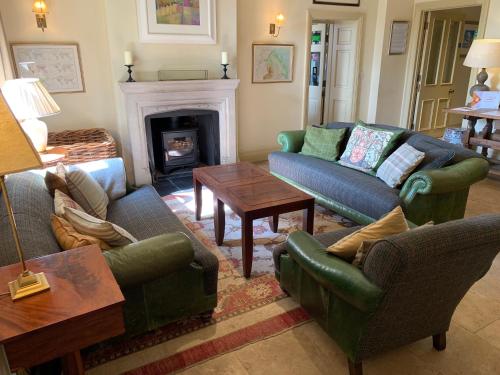 a living room with couches and a fireplace at Collingwood Arms Hotel in Cornhill-on-tweed
