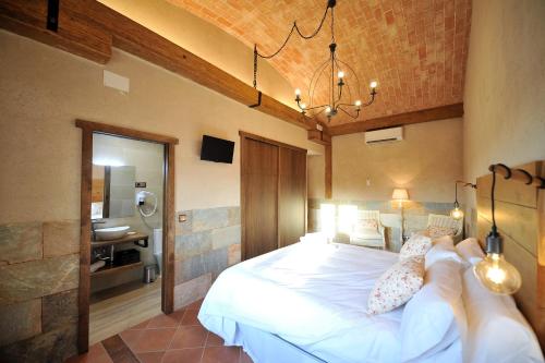 a bedroom with a large white bed in a room at Casa Rural Alma Del Tajo, Toledo, Puy Du Fou in Albarreal de Tajo