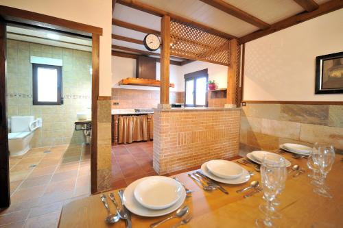 un comedor con una mesa con platos. en Casa Rural Alma Del Tajo, Toledo, Puy Du Fou en Albarreal de Tajo