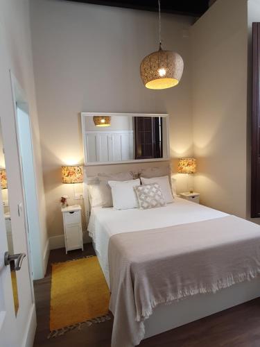 セビリアにあるApartamento Arenalのベッドルーム(大きな白いベッド1台、ランプ2つ付)