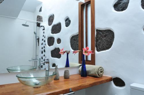 baño con lavabo y espejo en El Susurro Ecoliving VILLA GUINCHO, en San Juan de la Rambla