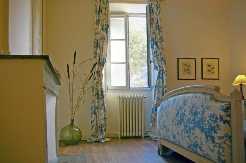 une chambre avec un lit et une fenêtre dans l'établissement Les chambres Anglaises, à Largentière