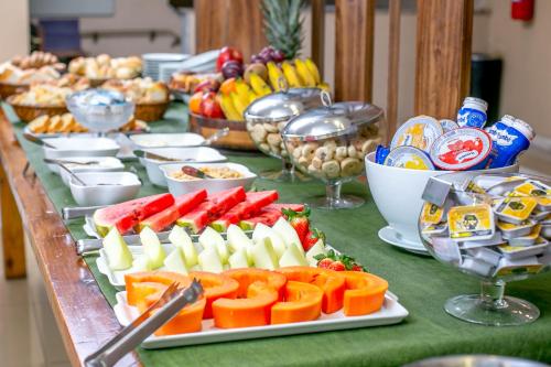 una tavola con frutta e altri prodotti alimentari di Hotel Flat Itaipava a Itaipava