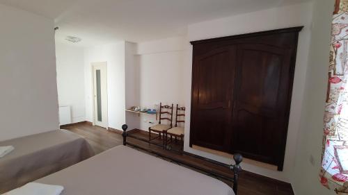 una camera con un letto e una grande porta in legno di DOMU NOSTA di Giulio & Ignazia Room2 a Santa Luria