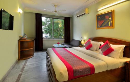 a bedroom with a bed and a chair and a window at Hotel Pablas International, New Delhi, Near Metro in New Delhi