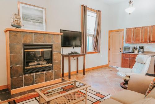 a living room with a fireplace and a tv at Cobble Wood and Bird Sanctuary Guest Houses in Tofino