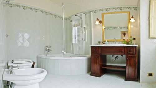 a bathroom with a tub and a toilet and a sink at Casa Barone Agnello in Cefalù