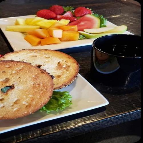 a sandwich on a plate next to a plate of fruit at Cape Fox Lodge in Ketchikan
