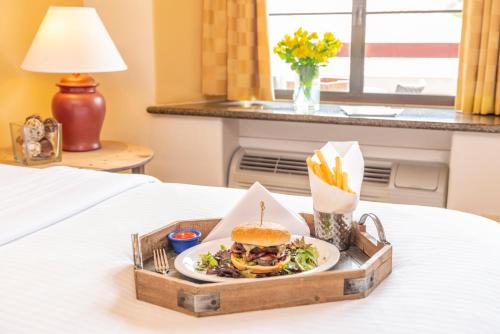 a sandwich and salad in a tray on a bed at Clocktower Inn Ventura in Ventura