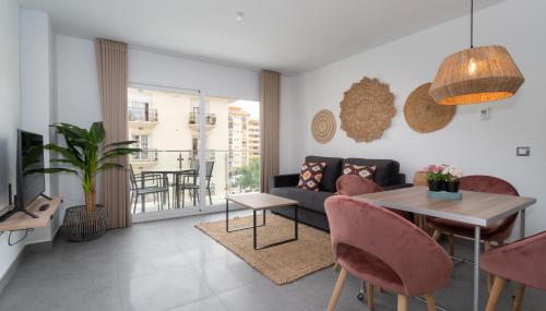 uma sala de estar com um sofá e uma mesa em Sur Suites La Dorada em Fuengirola