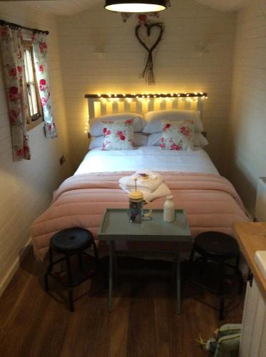a bedroom with a bed with a table and chairs at Llangollen Shepherds Huts in Llangollen