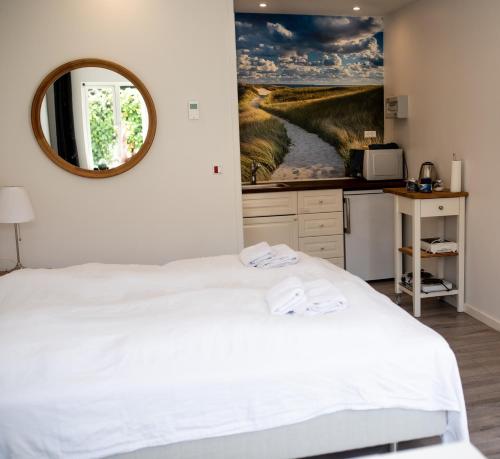 um quarto com uma cama branca e um espelho em EngholmBB em Odense