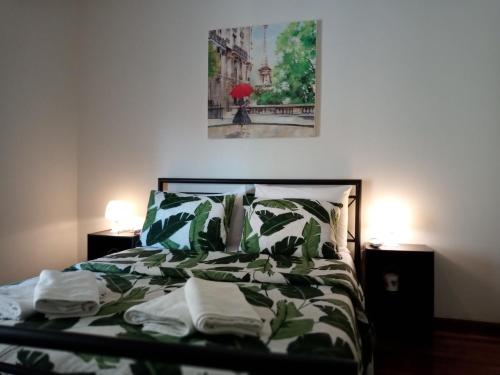 um quarto com uma cama com um edredão verde e branco em Afrodite's apartment (close to Athens city center) em Atenas