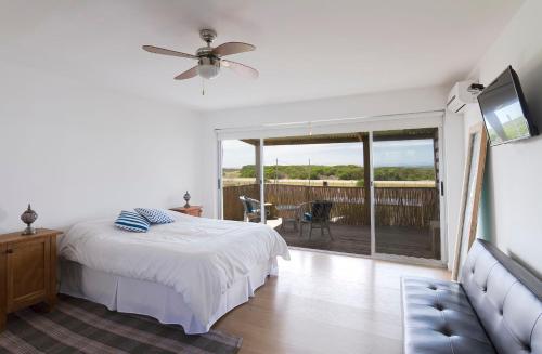 a bedroom with a bed and a balcony with a patio at Loft de Mar in José Ignacio