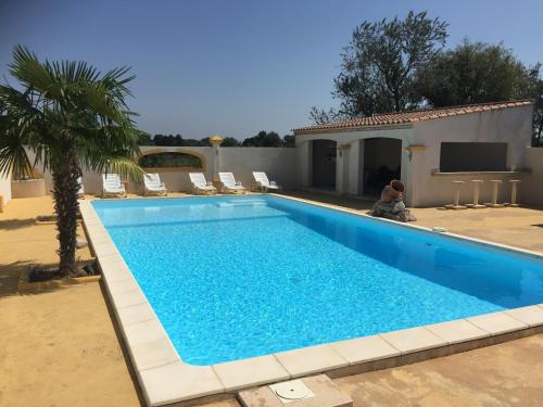 a person sitting next to a swimming pool at EL ROCIO 1 GITES EQUESTRE in Saintes-Maries-de-la-Mer