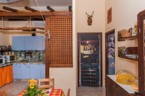 Il Covo degli Artisti في Campobello di Licata: مطبخ مع دواليب بيضاء وطاولة في الغرفة