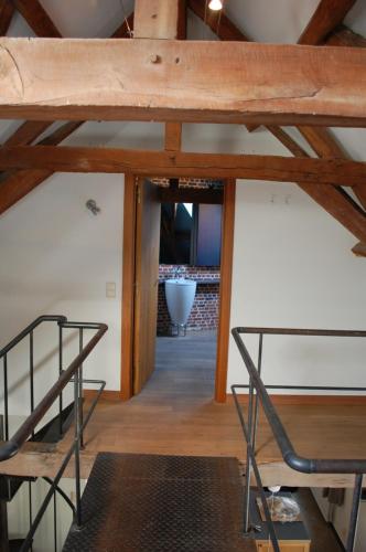 a view from the loft of a room with a wooden ceiling at Rubbensloft in Zele