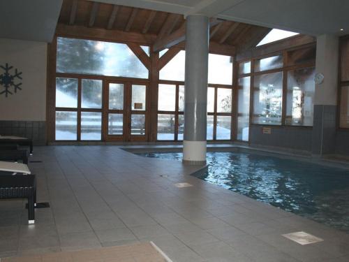 a large swimming pool in a building with windows at Les Chalets de Wengen - La Panoramique in Les Coches