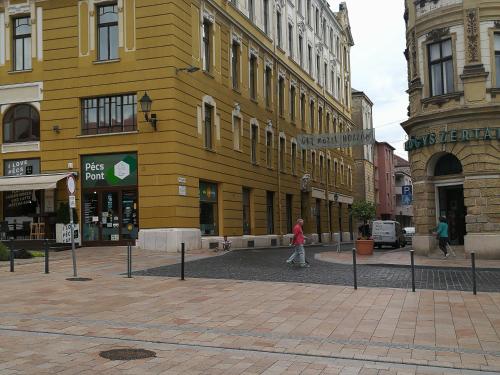 a yellow building on a street in a city at CENTRUM11 in Pécs