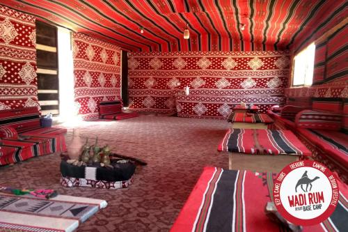 Zimmer mit roten Wänden und einem Tisch in der Unterkunft Wadi Rum Desert Base Camp in Wadi Rum