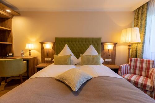 a hotel room with a large bed and two chairs at Parkhotel in Bad Waldsee