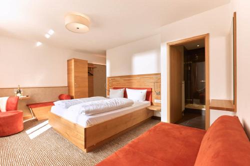 a bedroom with a bed and a couch at Gasthof-Hotel Pietsch in Freystadt