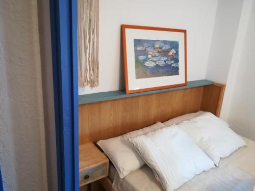 un letto in una camera con una foto sul muro di Olivia V a Tarragona