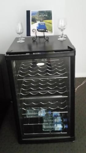 a black cabinet with two wine glasses on top at C'est La Vie Bed & Breakfast in Albany