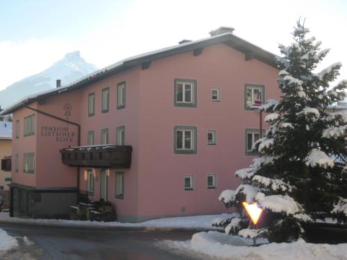 a pink building with a tree in front of it at Pension Gletscherblick in Fulpmes