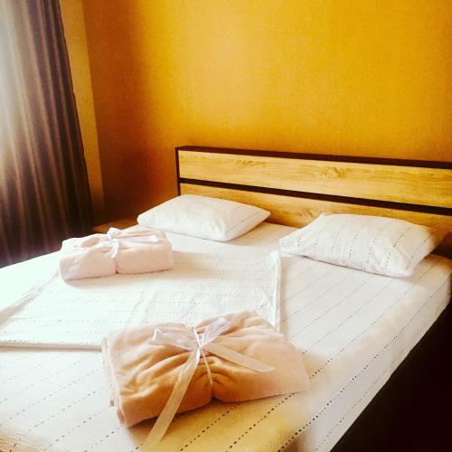 a bed with two white towels on top of it at Apartament - Axis palace saburtalo in Tbilisi City