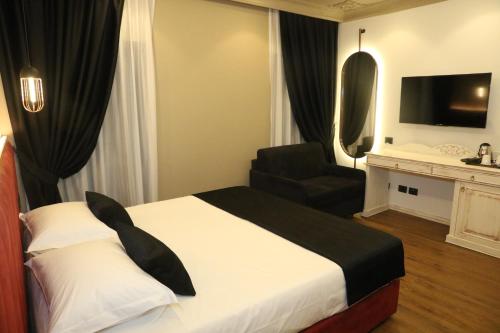 a hotel room with a bed and a chair at Hotel Kloest in Durrës