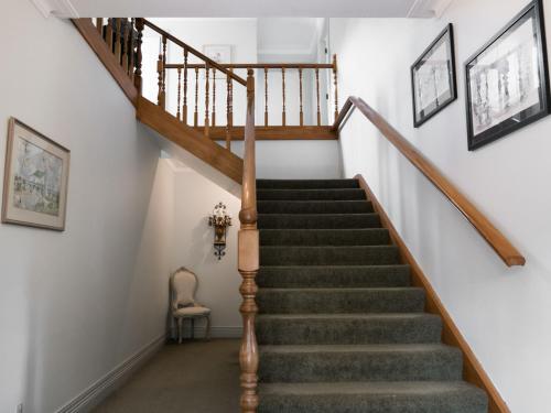 a staircase in a home with a wooden stair case at Goodin Country Garden in Okato