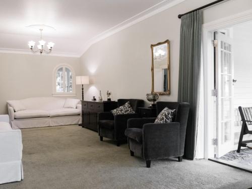 a living room with a couch and chairs at Goodin Country Garden in Okato