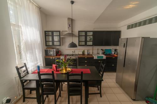 a kitchen with a table with chairs and a refrigerator at Sopron City Apartment in Sopron