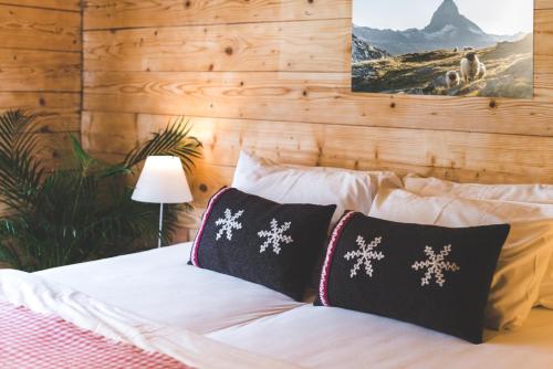 una camera da letto con un letto con cuscini a fiocchi di neve di Aroleid Lodge a Zermatt