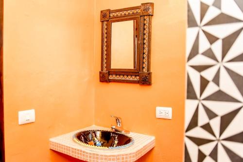 a bathroom with a sink and a mirror on the wall at Tribu Hostel in Holbox Island