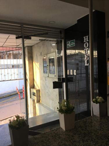 a building with two potted plants in front of a door at Hotel Garden City Boutique in Fusagasuga