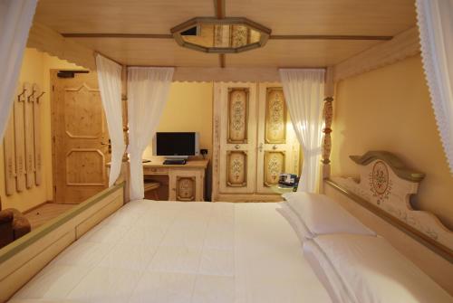 una camera con letto bianco e scrivania di Hotel Bes & Spa a Claviere