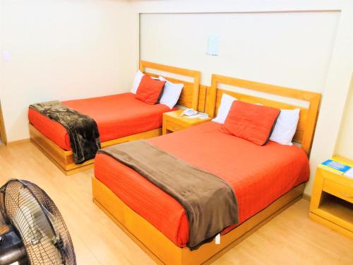Habitación con 2 camas y ventilador. en Hotel & Suites Victoria en San Luis Potosí