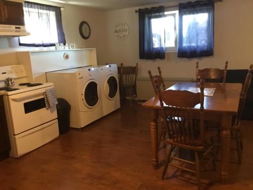 a kitchen with a table and a washing machine at BeachView Apartment in Port Hood