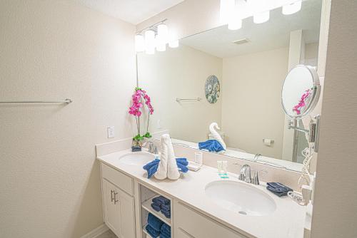 Un baño con lavabo y un espejo grande. en Only 5 Miles from Disney! Free Water Park! 2 Bed, 2 Bath Condo, Sleeps 8, en Kissimmee
