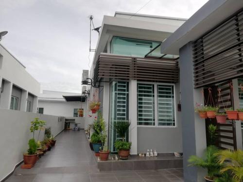 a house with potted plants in a courtyard at Kkp home stay in Alor Setar